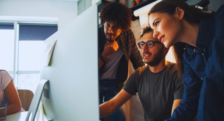 Jeunes collegues regardant un ecran d ordinateur au bureau