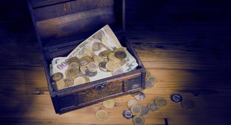 Coffre en bois rempli de pieces et de billets