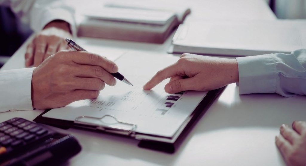 Deux personnes examinant des documents contractuels au bureau